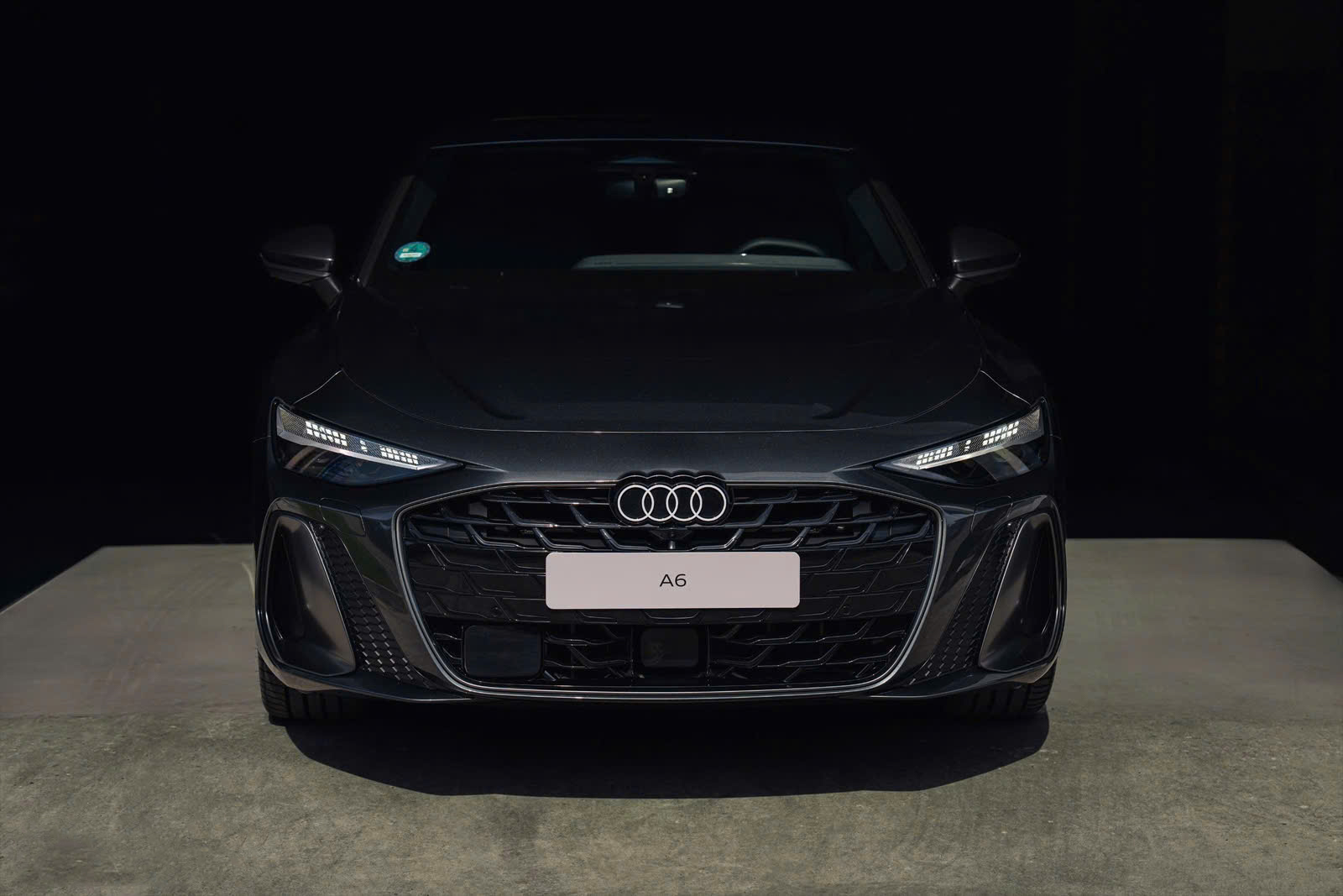 Đầu xe Audi A6 2026 cuốn hút nhờ bộ lưới tản nhiệt lục giác Singleframe cỡ lớn, bên trong chứa nhiều nan đơn mạ crom sáng bóng chạy ngang